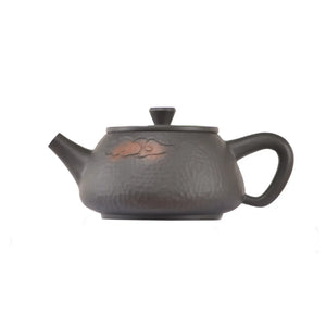Side view of clay teapot No.14 showing hammered surface and cloud pattern design