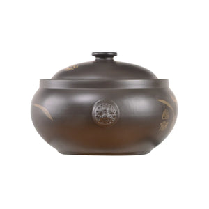 This is a Jianshui zitao black steamer, with a round body decorated with an orchid pattern, and it comes with a matching lid