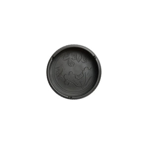 Top view of a handmade pottery ashtray with carved lotus leaf and fish design