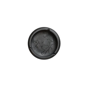 Top view of a handmade pottery ashtray with carved fish and lotus leaf design