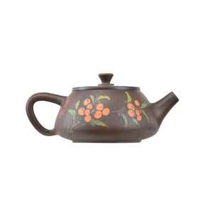 Bronze clay teapot with hand-carved floral and berry design, rounded body, side handle, and spout.