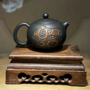 Handcrafted clay teapot with traditional carved and inlaid decoration