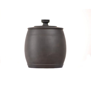 Back view of an unglazed, hand-polished pottery tea canister with a smooth matte dark clay surface and clean, minimalist silhouette.