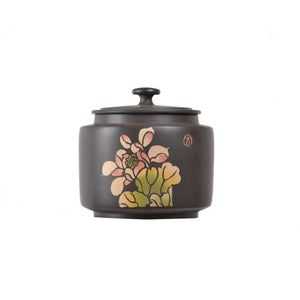 Jianshui zitao tea canister with hand-carved floral decoration and hand-inlaid colored clay details on a matte dark clay body