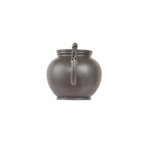 Jianshui zitao black clay teapot with rounded body, smooth finish, and perforated handle design, back view.