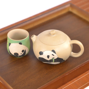 Jianshui zitao teapot and matching cup with hand-engraved panda design, displayed together on a wooden tray