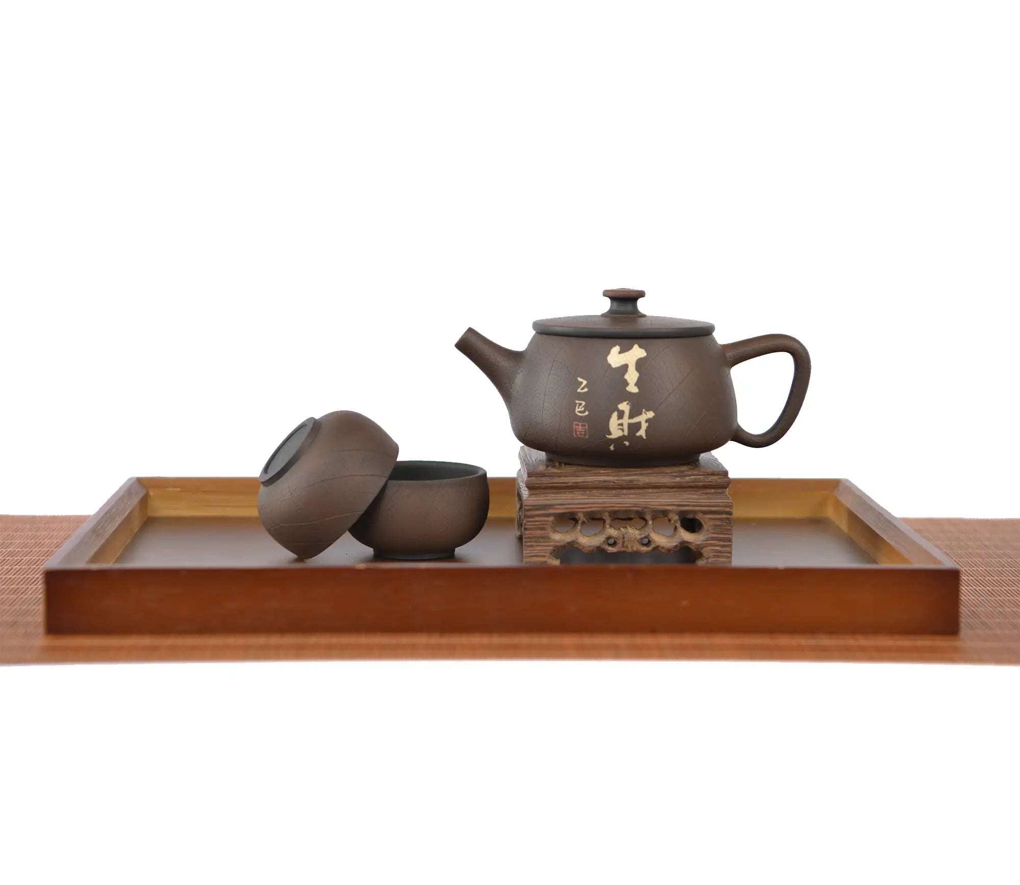 Handcrafted unglazed pottery teapot with a Bodhi-style crackle texture and engraved Chinese calligraphy, displayed with two matching teacups on a wooden stand and tray.