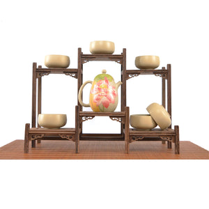Handcrafted white clay lotus teapot set with six matching cups, featuring a hand-carved lotus floral design, displayed on a wooden tea stand.