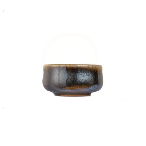 Jianshui zitao wood-fired cup showing layered earthy coloration shaped by flame, side view