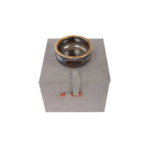Jianshui zitao wood-fired cup displayed on box, highlighting natural ash glaze variations.