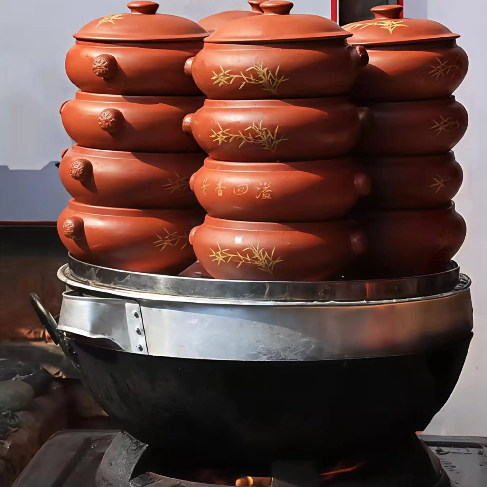 Jianshui zitao steam pots stacked on a stove while cooking food