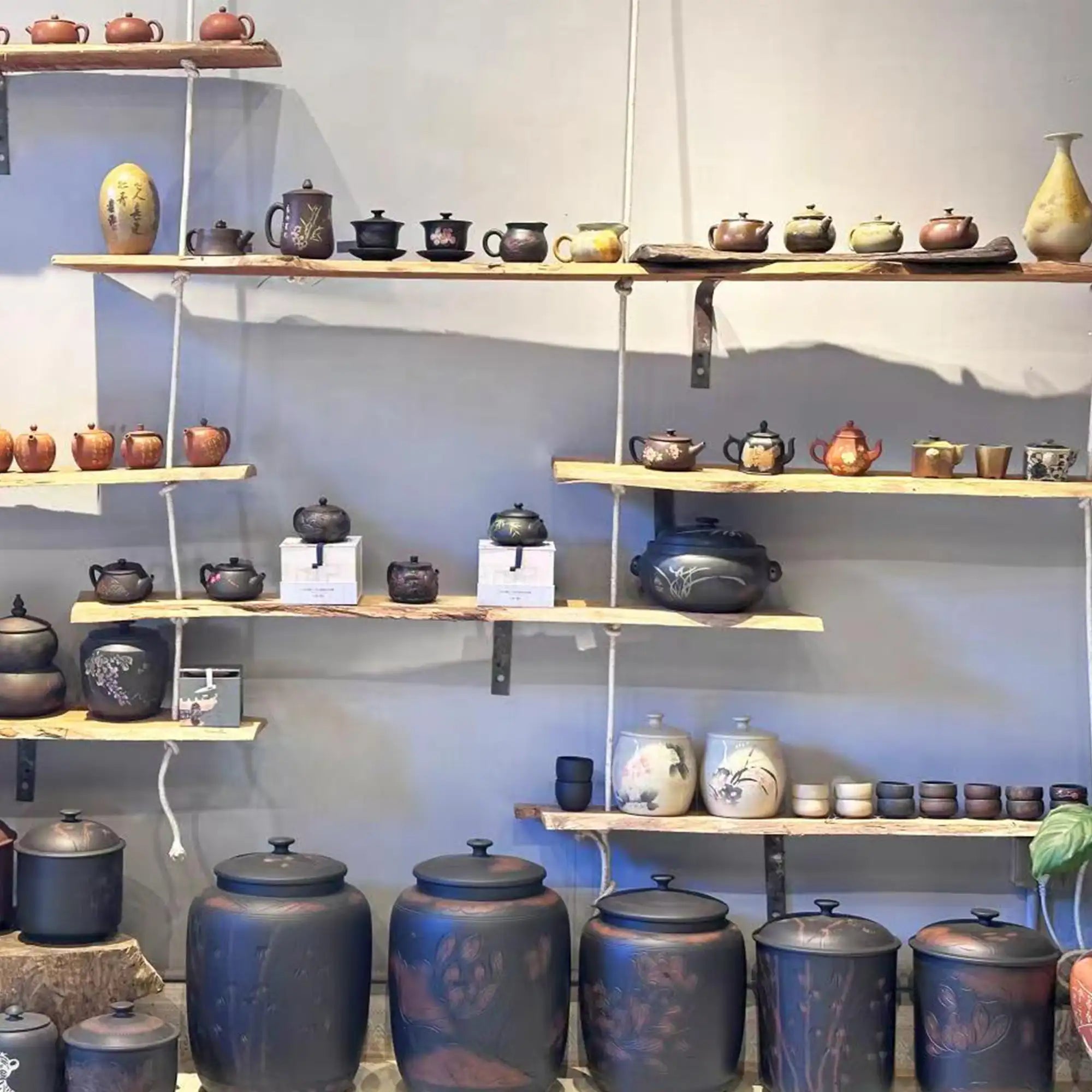 Local retail store display showcasing Jianshui zitao teapots, tea canisters, and handcrafted pottery