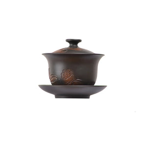 Jianshui zitao Gaiwan tea bowl with hand-carved lotus flower design, shown with a matching saucer