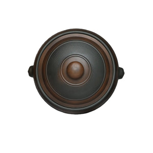 Top view of a handmade pottery steam pot lid with textured surface.