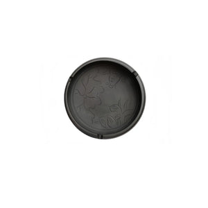 Top view of a Jianshui zitao ashtray with carved fish and lotus flower design