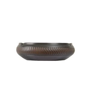 Side view of a handmade pottery ashtray with a chattering-carved texture and shallow bowl form