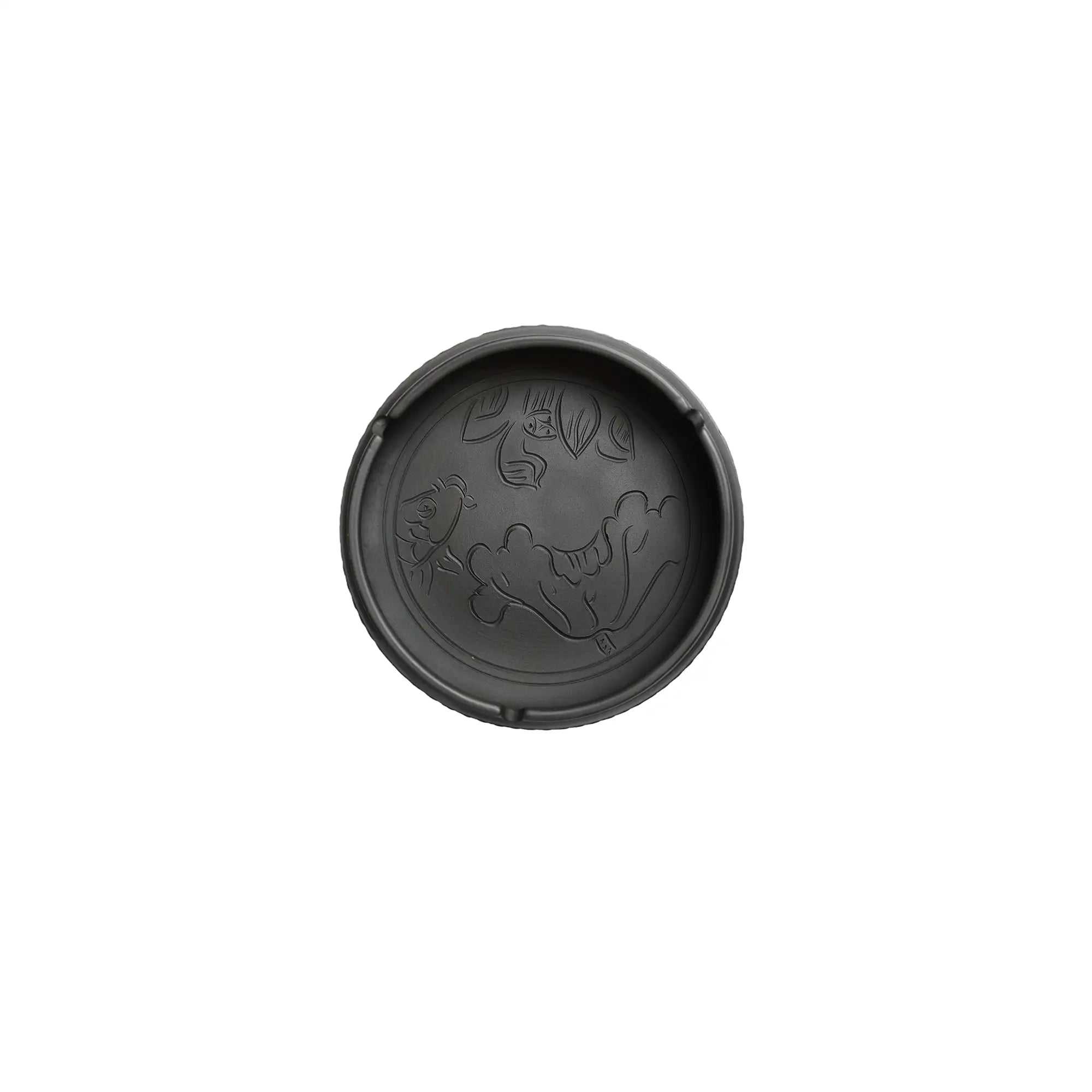Top view of a handmade pottery ashtray with carved lotus leaf and fish design