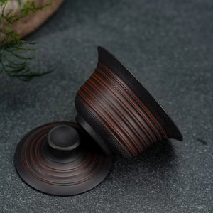Side view of handmade Jianshui clay gaiwan showing textured surface