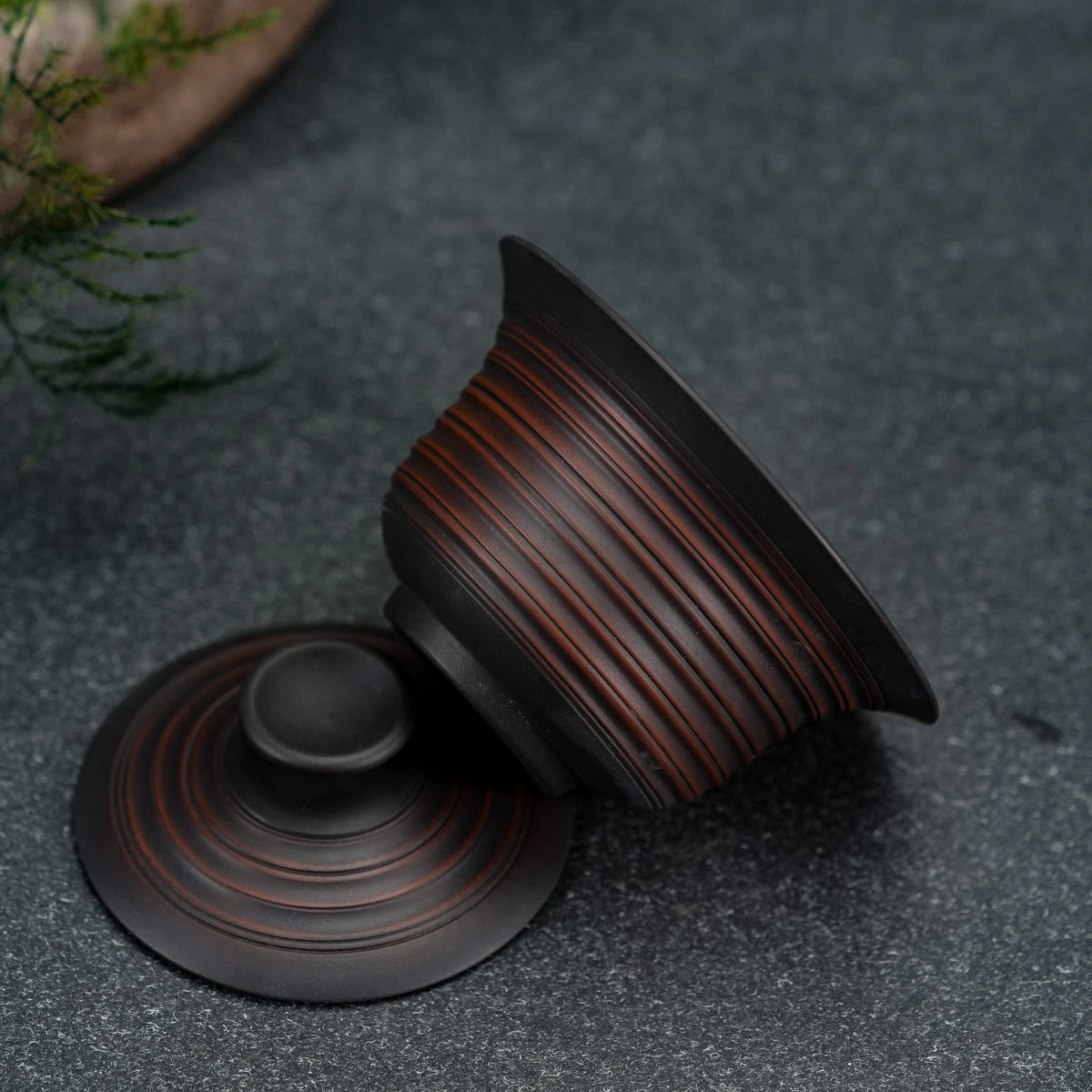 Side view of handmade Jianshui clay gaiwan showing textured surface