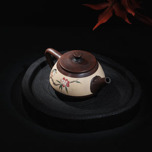 Angled view of Jianshui clay teapot with bird motif inlay