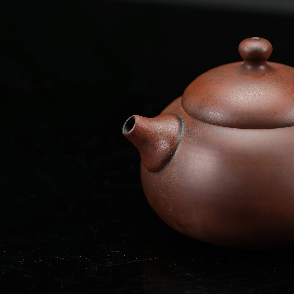 Close view of handmade Jianshui rounded red clay teapot