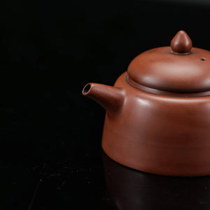 Side view of handmade Jianshui red clay teapot