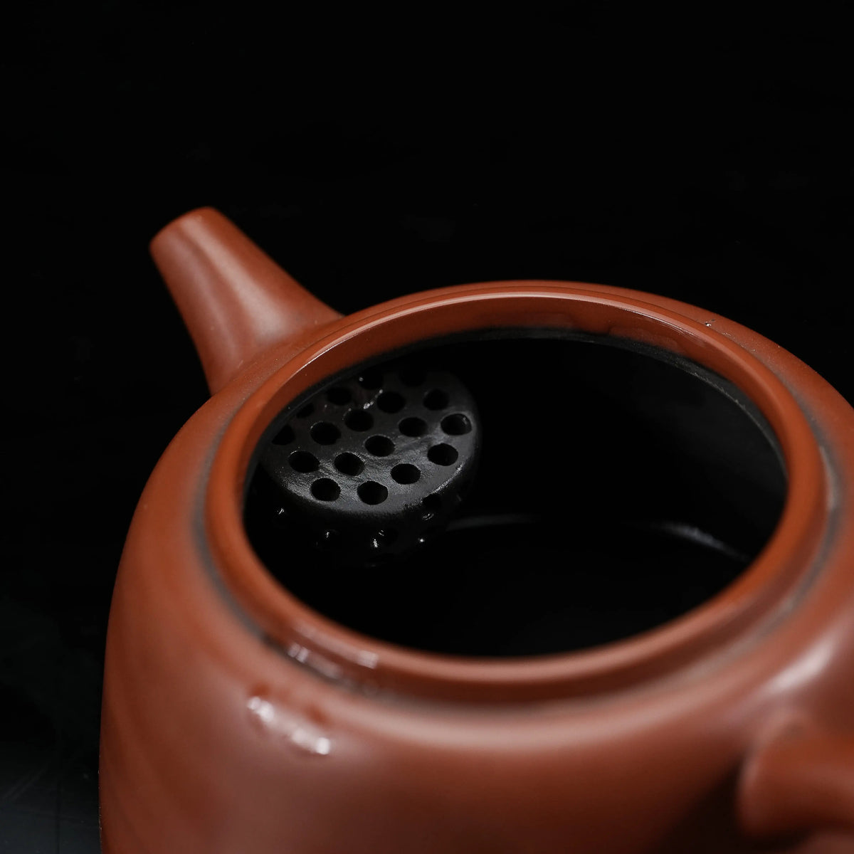 Open Jianshui red clay teapot showing the built-in filter