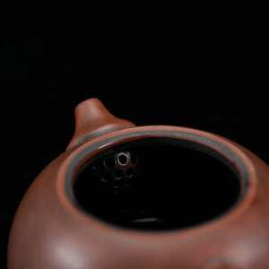 Open Jianshui red clay teapot showing the built-in filter