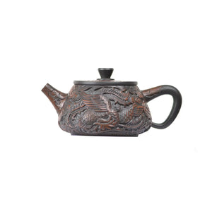 Side view of handcrafted Jianshui Zitao Xishi teapot No.32 highlighting intricate dragon and phoenix carving craftsmanship
