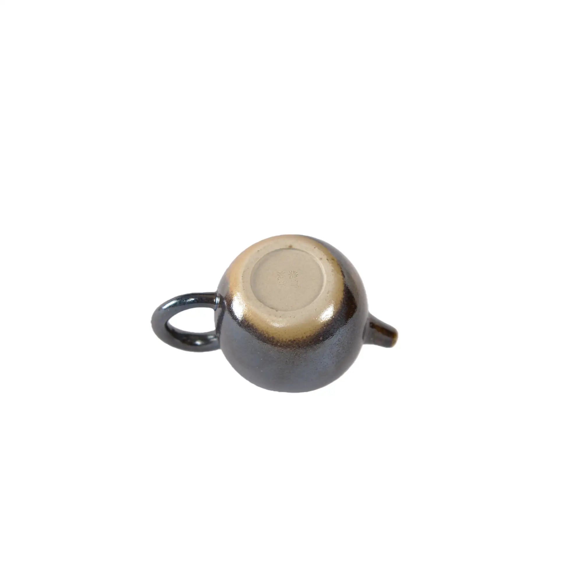 Bottom view of PorSva No.65 wood-fired Jianshui clay teapot displaying natural kiln marks
