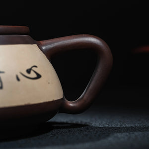 Contrasting inlay and calligraphy detail on Jianshui clay teapot