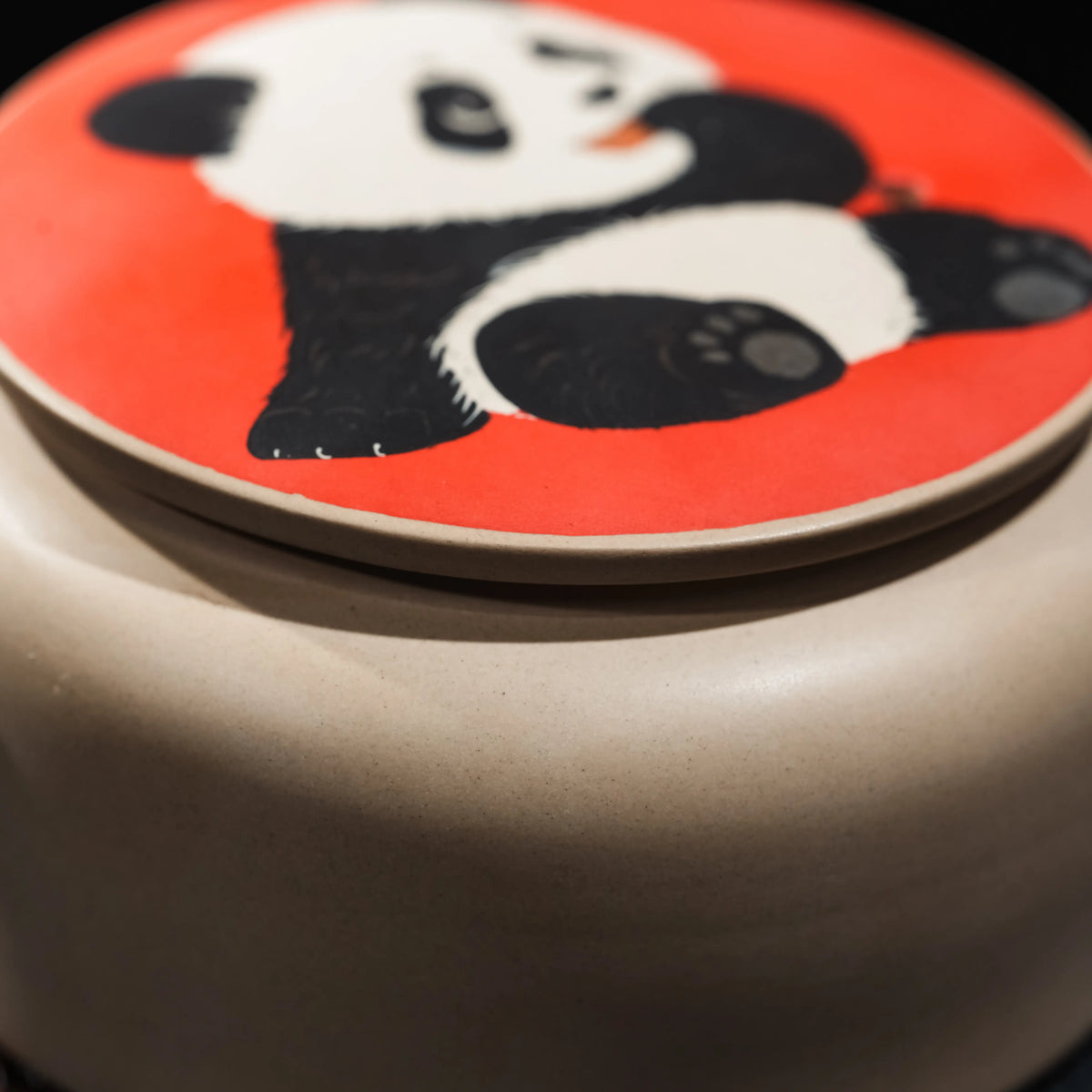 Close view of carved and clay-inlaid panda decoration on teapot lid