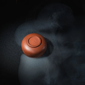 Bottom view of handmade Jianshui plain red clay tea cup