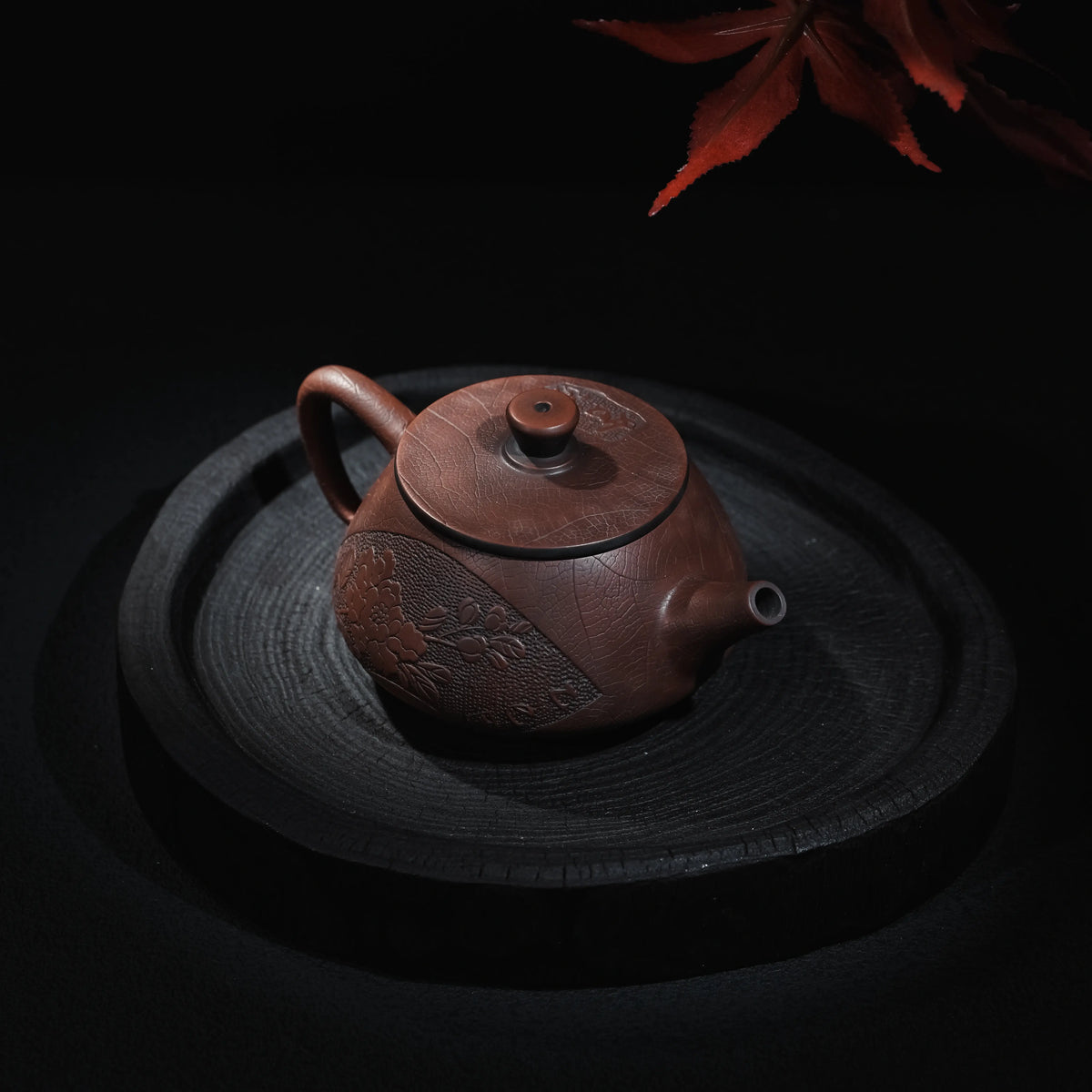 Angled view of Jianshui Shi Piao teapot with relief decoration