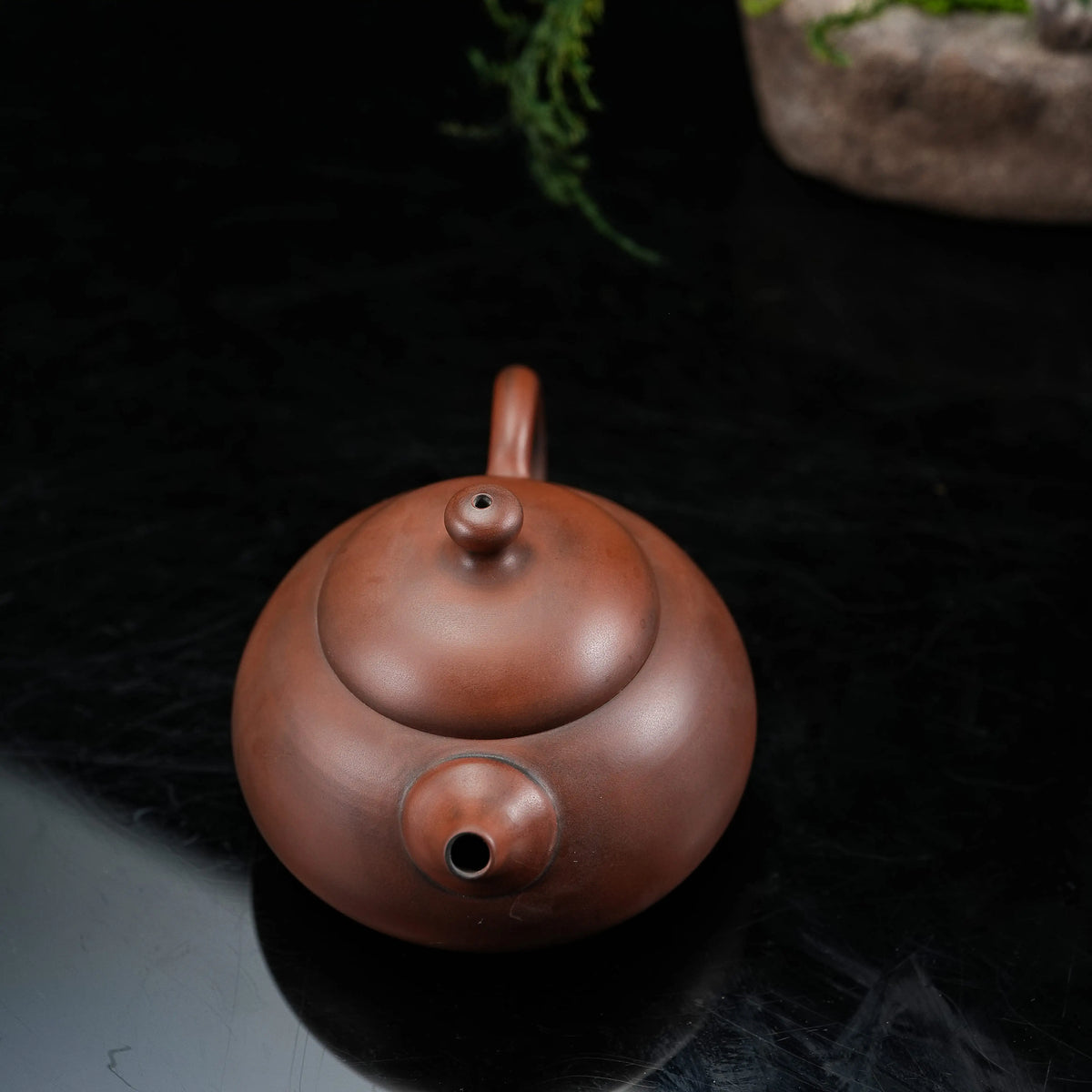 Top view of handmade Jianshui rounded red clay teapot