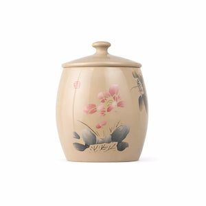 Handmade pottery tea canister with an unglazed, burnished finish and hand-carved lotus flower design.