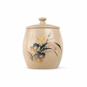 Handmade pottery tea canister with an unglazed, burnished finish and a hand-carved orchid design.