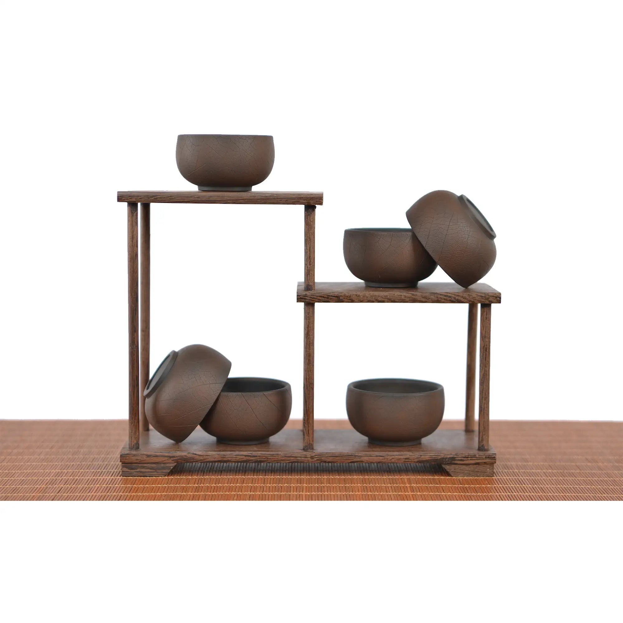 Jianshui zitao tea cups warm brown tone with a bodhi-leaf–inspired texture, arranged on a wooden display stand