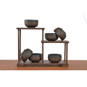 Set of smallJianshui zitao tea cups featuring chattering-carved surfaces, displayed on a wooden stand