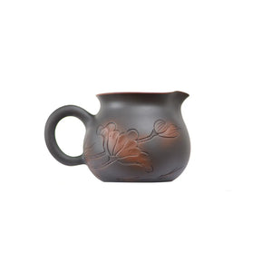 Side view of a Jianshui zitao fairness pitcher (gongdao cup) featuring hand-carved lotus details and a curved handle