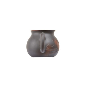 Back view of a Jianshui zitao fairness pitcher (gongdao cup) with a smooth unglazed matte surface and gently curved handle