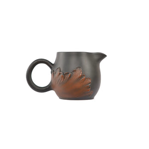Side view of a Jianshui zitao fairness pitcher with applied lotus leaf relief carving and unglazed matte surface