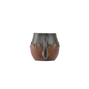 Back view of a Jianshui zitao fairness pitcher showing the curved handle and lotus leaf relief carving