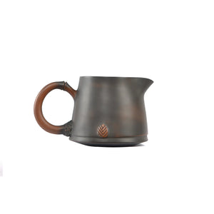 Side view of a Jianshui zitao fairness pitcher featuring a root-inspired handle and a subtle leaf relief near the base