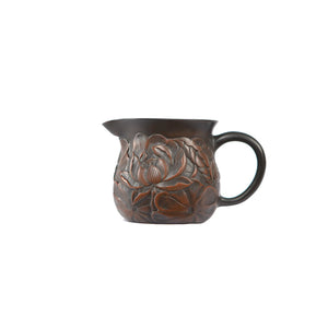 Side view of a Jianshui zitao fairness pitcher with fully carved lotus relief covering the pottery surface
