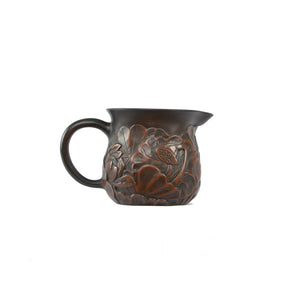 Side view of a Jianshui zitao fairness pitcher featuring full lotus relief carving with layered sculptural detail
