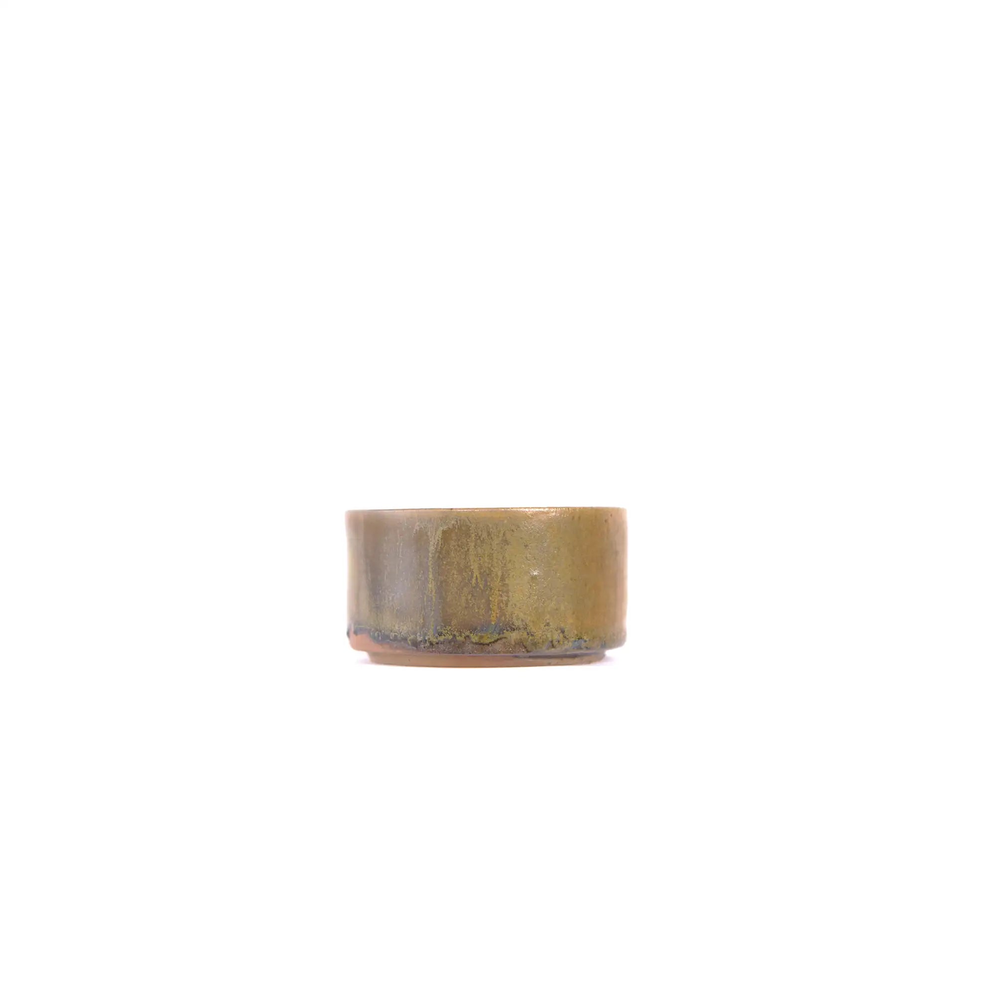 Side view of a wood-fired Jianshui zitao tea cup showing natural ash deposits and kiln-fired surface variation