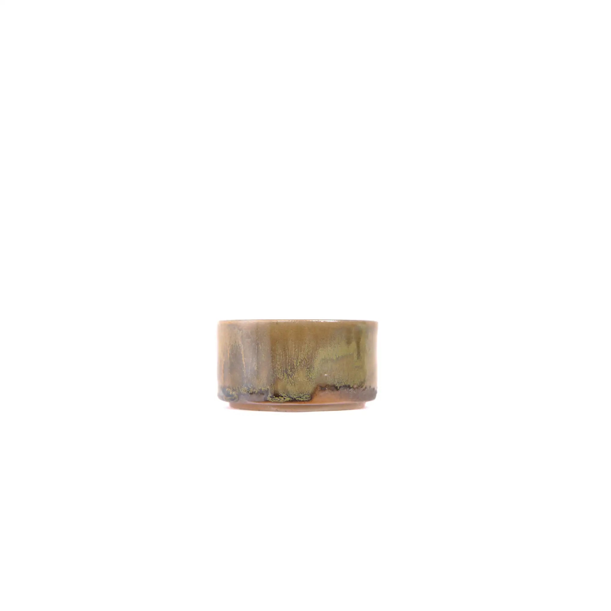 Side view of a wood-fired Jianshui zitao tea cup highlighting layered kiln marks and earthy surface tones