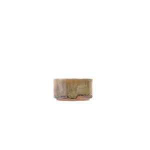 Side view of a wood-fired Jianshui zitao tea cup highlighting layered kiln marks and earthy surface tones