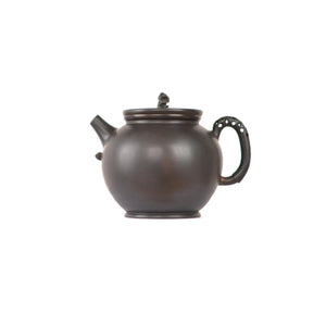Jianshui zitao black clay teapot with smooth unadorned surface, side view.